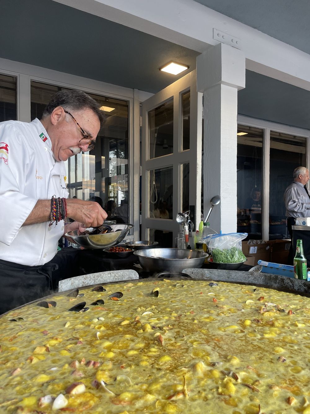 El chef de Paellas Ibarra agregando mejillones a una paella gigante en un evento